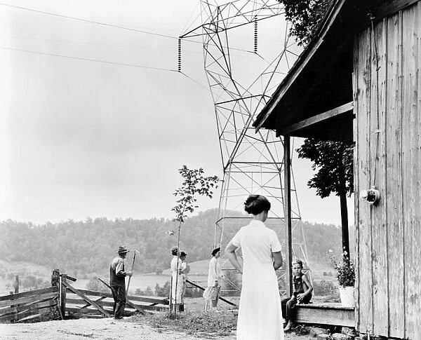 A family receives power at their home, indicated by the meter on the side of the house, provided by the Tennessee Valley Authority, c1935