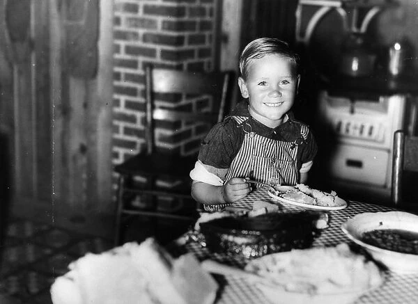 FARM BOY, 1940. Child of a former sharecropper eating at a table in southeast Missouri