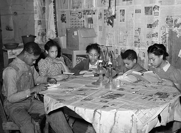 FARM CHILDREN, 1940. A farmers five children studying their reading lessons at