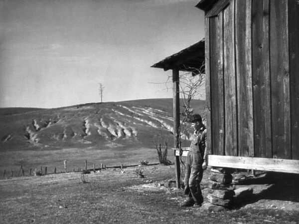 FARM EROSION, 1937. Farm boy on badly eroded land from the Dust Bowl of Oklahoma. Photograph by Arthur Rothstein, 1937