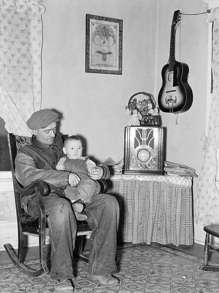 FARMER AND SON, 1937. A farmer with his son at home in Crosby, North Dakota, during