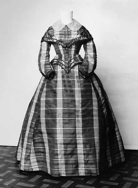 FASHION: DRESS, c1865. Black, brown and cream colored silk plaid dress, American, c1865