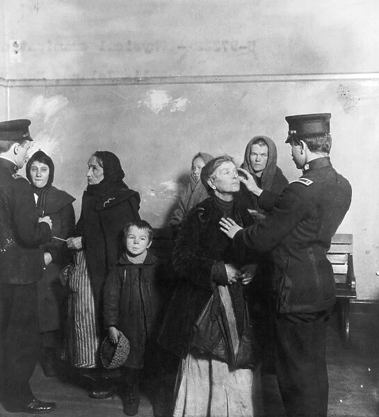 Federal inspectors examining the eyes of immigrants at the immigration station in New York Harbor, c1911