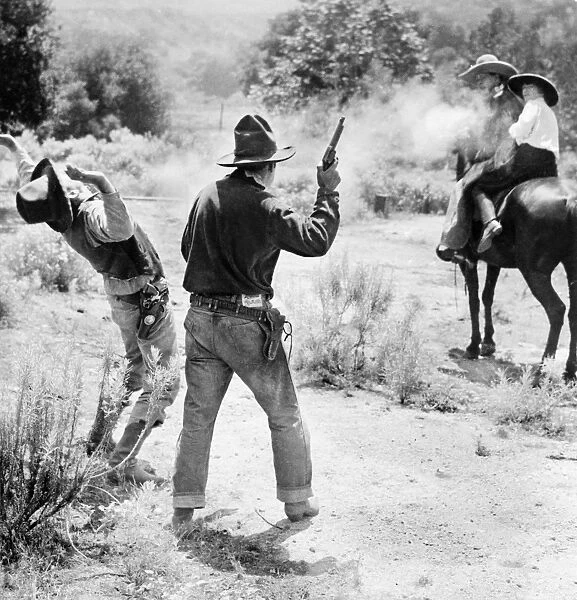 FILM: HIGHWAYMAN, c1926. Western film still of a shootout between actor Jack Hoxie with actress Helen Holmes on horseback, and two men on foot. Stereograph, c1926