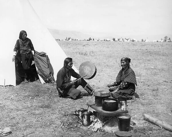 FLATHEAD COUPLE, c1905. Mose Vandenburg, a Flathead Native American, playing a