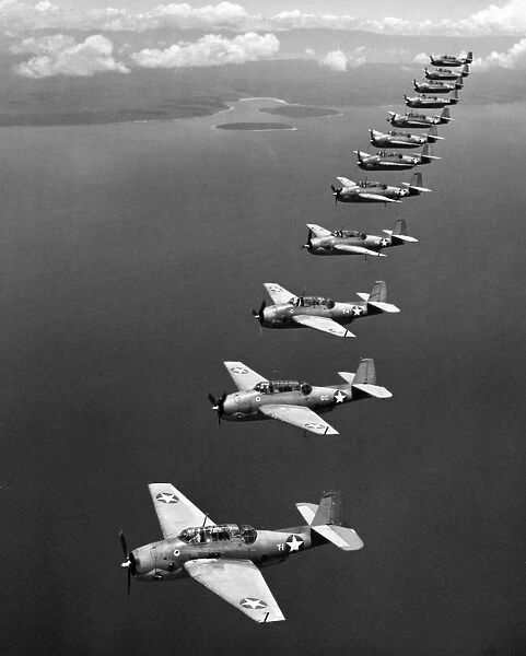 A flight of twelve Grumman Avenger torpedo-bombers over the South Pacific, 1943, during World War II
