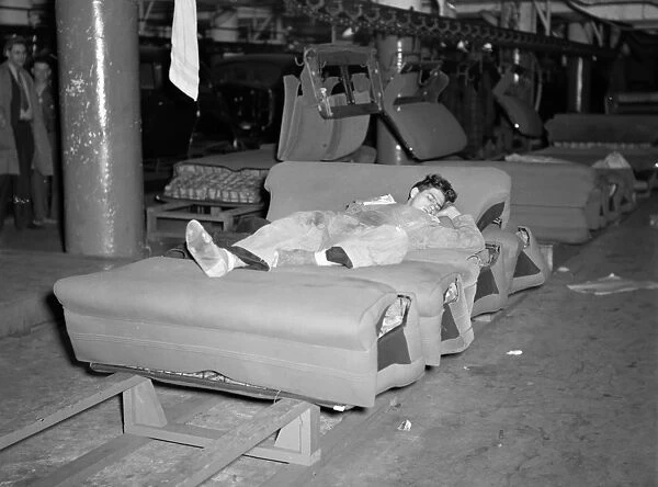 FLINT SIT DOWN STRIKE, 1937. A striker sleeping on an assembly line of auto seats