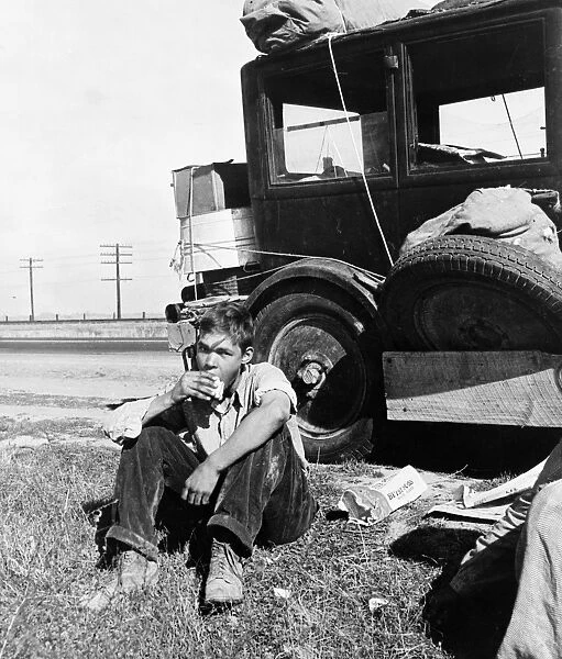 FLOOD REFUGEE, 1936. A son of a migrant worker eating roadside while traveling