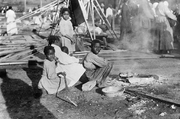 FLOOD REFUGEES, 1912. Refugees from a flood in Louisiana cooking government rations
