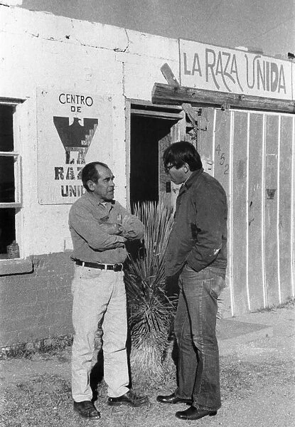 Florencio Arciniega, Jr. (right), a college student working for the Arizona State Employment Service under the federal UYA (University Year for ACTION) program, speaking with Antonio Gomez, a maintenance worker for the Chicano rights organization La Raza Unida, in the border town of Douglas, Arizona, 1972