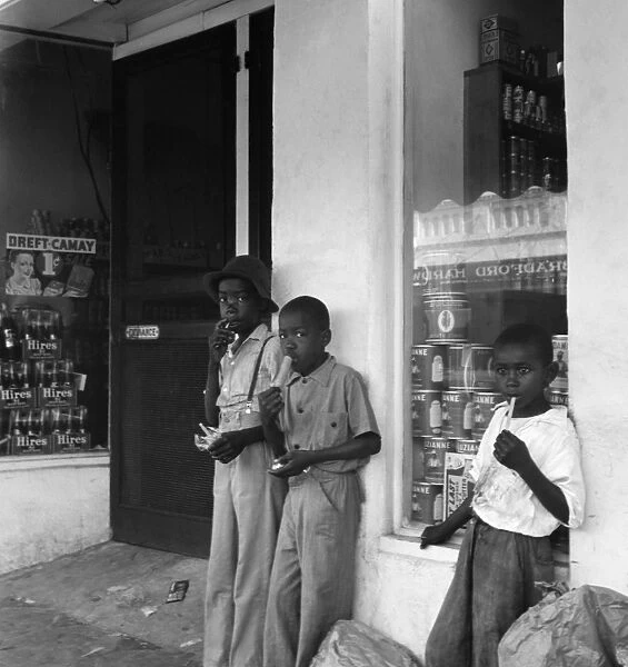 FLORIDA, 1941. Boys eating popsicles outside of a store in Starke, Florida. Photograph