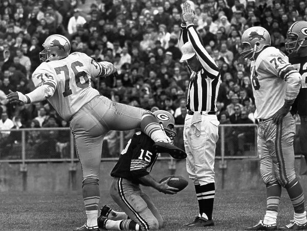 FOOTBALL GAME, 1965. Defensive tackle Roger Brown of the Detroit Lions exults after sacking quarterback Bart Starr of the Green Bay Packers (kneeling) in the end zone for a safety, during a game at Lambeau Field, Green Bay, Wisconsin, 7 November 1965