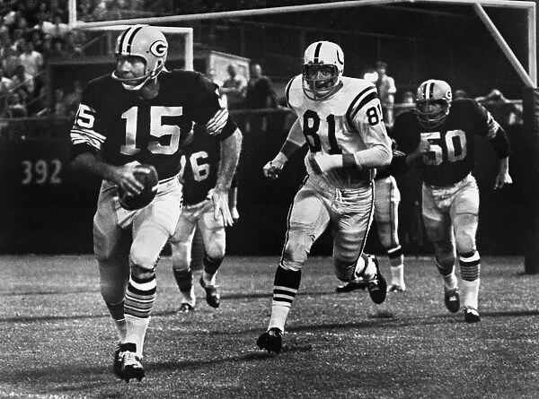 FOOTBALL GAME, 1966. Quarterback Bart Starr of the Green Bay Packers attempting to run for a first down against the Baltimore Colts after failing to find an open receiver, during a game at County Stadium, Milwaukee, Wisconsin, 10 September 1966