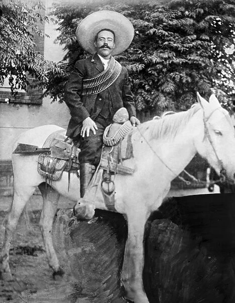 FRANCISCO PANCHO VILLA (1877-1923). Mexican revolutionary leader. Photographed wearing bandoliers mounted on a horse. Photograph, c1908-1919