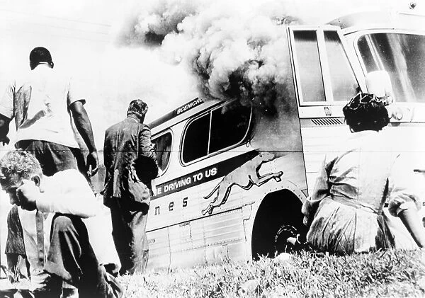 FREEDOM RIDERS, 1961. A group of Freedom Rider civil rights activists watch as their bus burns