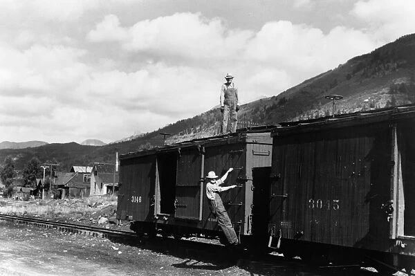 FREIGHT CAR, 1940. Railroad workers on the freight cars of a narrow gauge railway