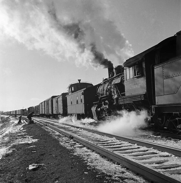FREIGHT TRAIN, 1943. Changing crews and cabooses on a westbound freight train along the Atchison, Topeka and Santa Fe Railroad, between Chicago and Chillicothe, Illinois. Photograph by Jack Delano, March 1943