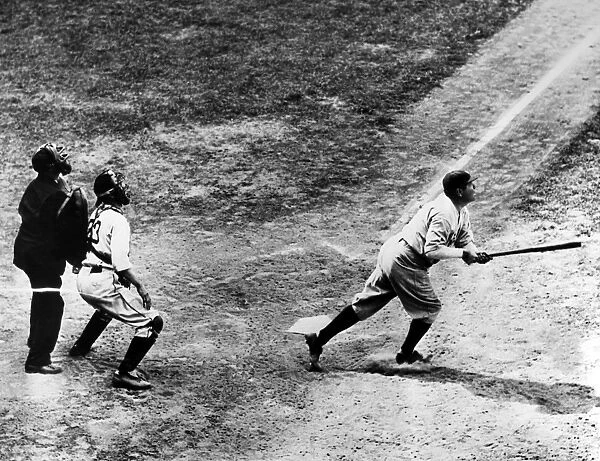 GEORGE H. RUTH (1895-1948). Known as Babe Ruth. American baseball player. As a member of the New York Yankees, hitting his 701st career home run off of pitcher Elden Auker of the Detroit Tigers, at Navin Field, Detroit, Michigan, 14 July 1934. Watching at left are Tigers catcher Ray Hayworth and home plate umpire Bill McGowan