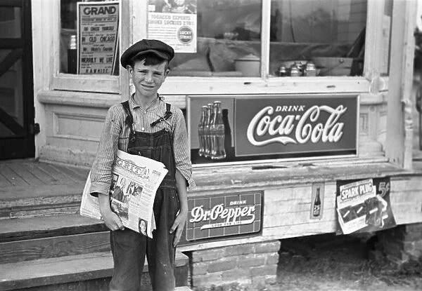 GEORGIA: NEWSBOY, 1938. A farmers son selling the newspaper Grit in a rural town, Irwinville, Georgia. Photograph by John Vachon in May 1938
