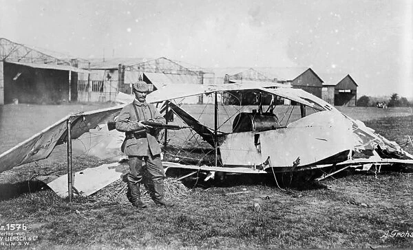 A German soldier guarding a wrecked airplane. Photograph, c1914