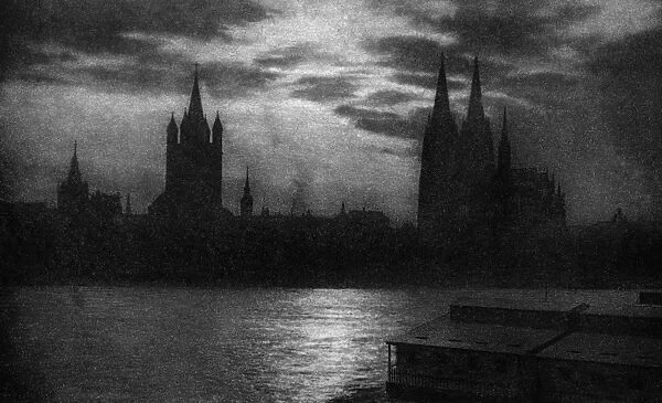GERMANY: COLOGNE, c1920. The Rhein River and Cologne Cathedral in the evening at Cologne, Germany
