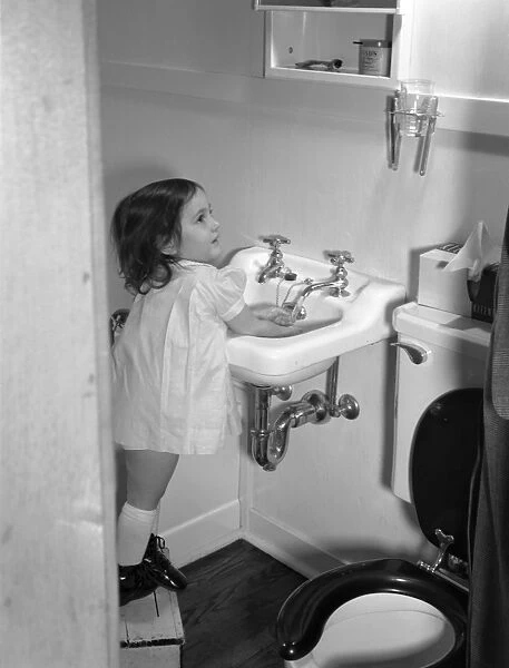 GIRL WASHING HANDS, 1942. Three-year-old Ann Heath, daughter of a Warren McArthur