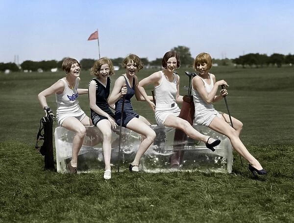 GOLFING, 1926. Women wearing bathing suits, sitting on a block of ice on a golf course