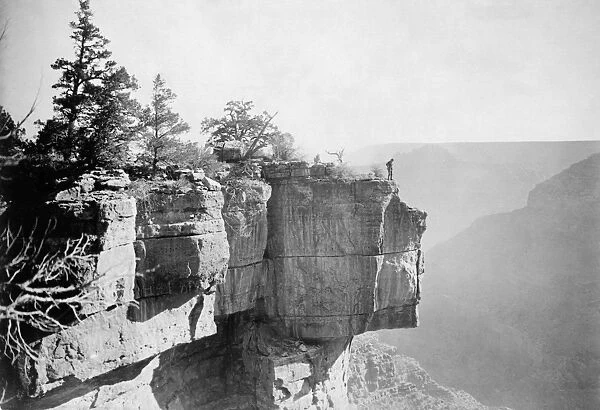 GRAND CANYON, c1906. A man standing on the ledge of a limestone cliff overlooking