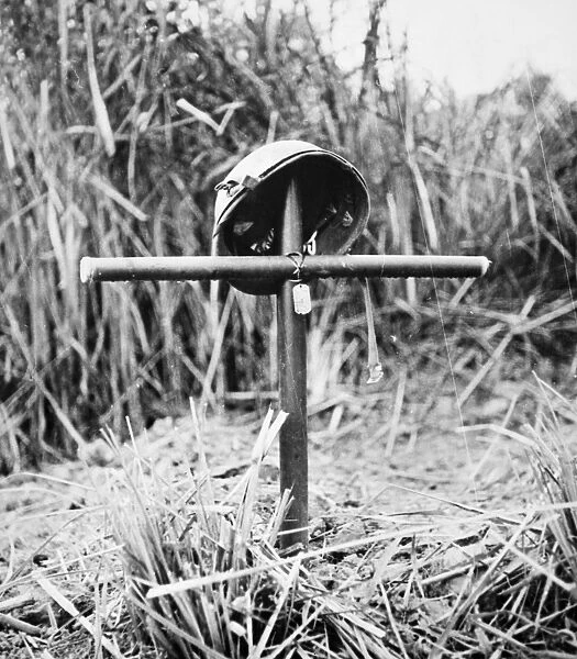 Grave for a U. S. Marine (marked by his dog tags) killed in action in the Pacific Theater, possibly at the Battle of Tarawa. Photographed March 1944