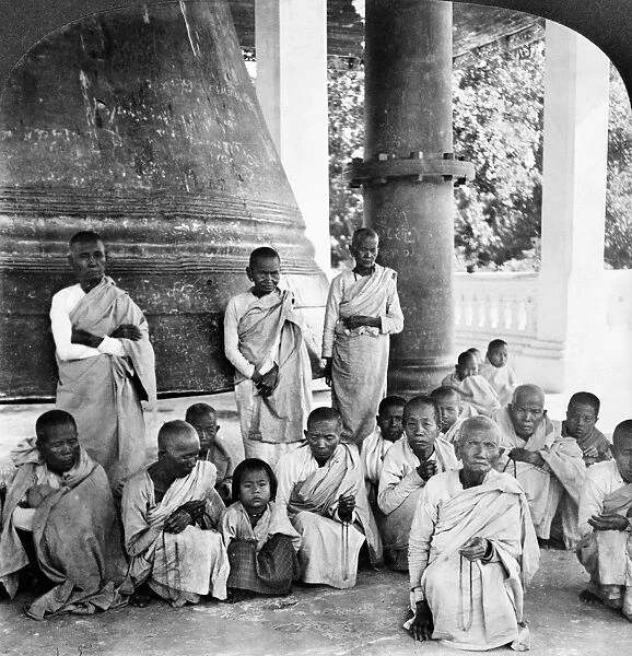 A group of Buddhist monks in front of the Great Bell of Mingoon at the temple, Mingoon, Burma. Stereograph, c1907