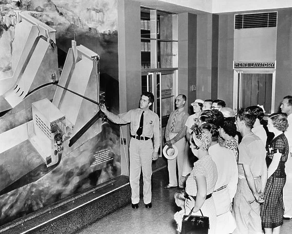 A guide explains the hydroelectric capabilities of the Norris Dam on the Clinch River in Tennessee, erected by the Tennessee Valley Authority, c1935