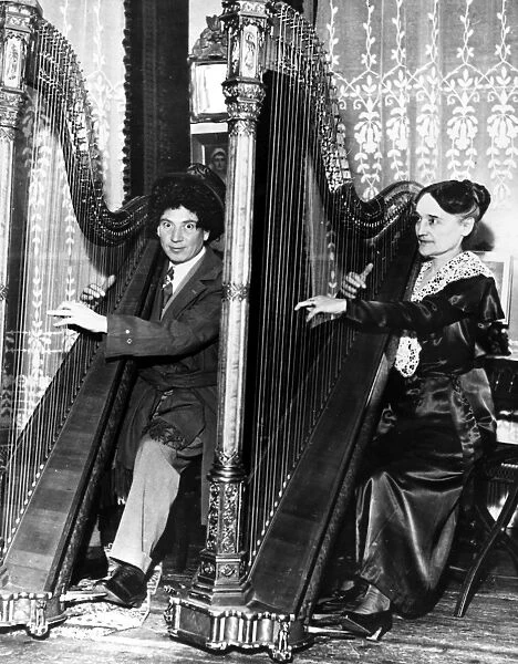 HARPO MARX (1888-1964). American comedian and actor. Photographed with French harpist Henriette Renis, at her home in Paris, France, 1933