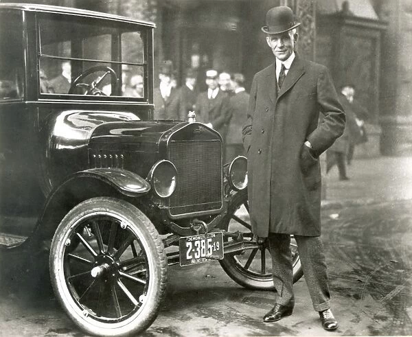 HENRY FORD (1863-1947). American automobile manufacturer. Photographed with one of his Model T automobiles, c1920