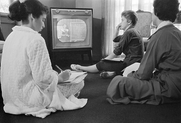 Three high school girls in Little Rock, Arkansas, sitting on the floor while learning a school lesson from the television at home when the Little Rock schools were closed to avoid integration, September 1958. Photographed by Thomas O Halloran