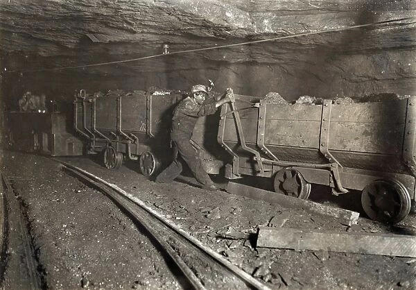 HINE: CHILD LABOR, 1908. A boy pulling the brake on a motor train filled with coal
