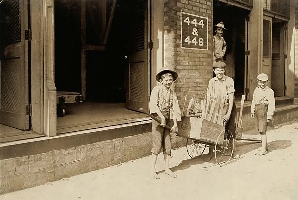HINE: CHILD LABOR, 1908. Boys carting home scrap wood for fuel from a factory they