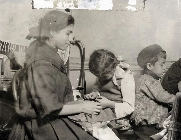 HINE: CHILD LABOR, 1910. Young garment workers sewing piecework in a tenement apartment