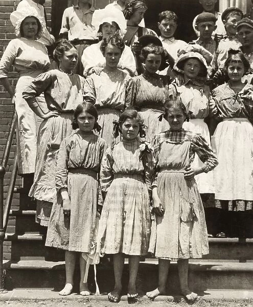 HINE: CHILD LABOR, 1912. A group of of young girls and woman standing outside the