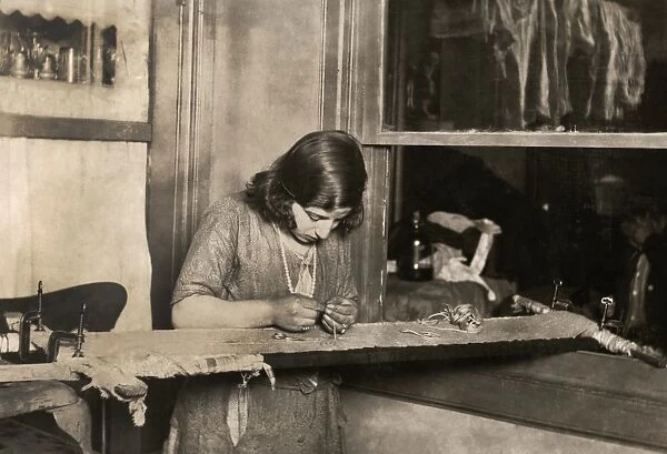 HINE: CHILD LABOR, 1923. A 13-year-old girl embroidering a dress by hand in Newark, New Jersey