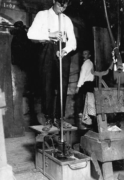 HINE: GLASS BLOWER, 1908. A glass blower with a foot mold at the Seneca Glass Works in Morgantown
