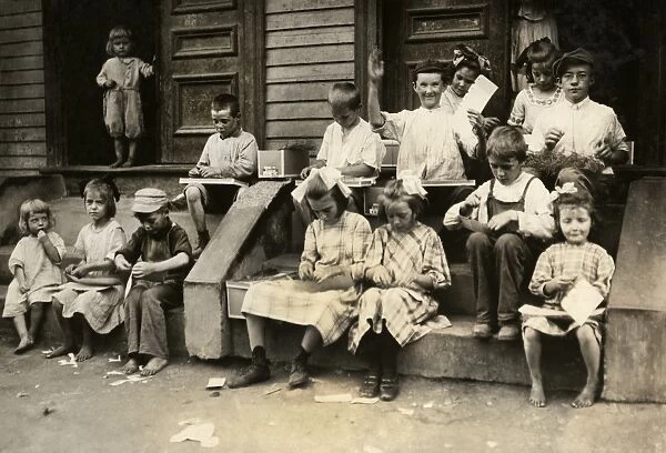 HINE: HOME INDUSTRY, 1912. Boys and girls working on garment tags on the steps