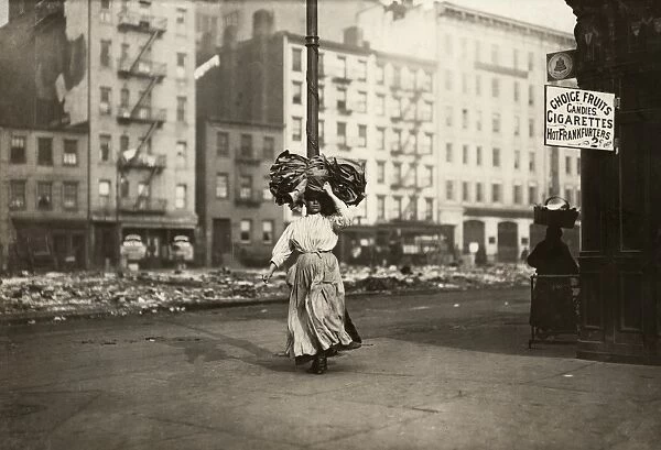 HINE: HOME INDUSTRY, 1912. An Italian immigrant woman carrying a heavy bundle of