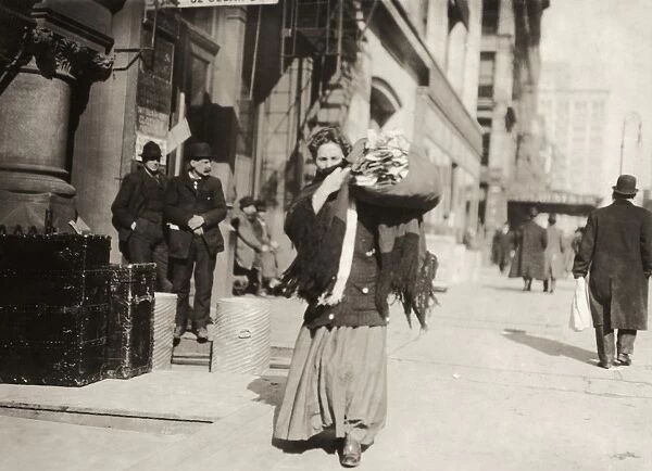 HINE: HOME INDUSTRY, 1912. A woman carrying a bundle of clothing for home-work