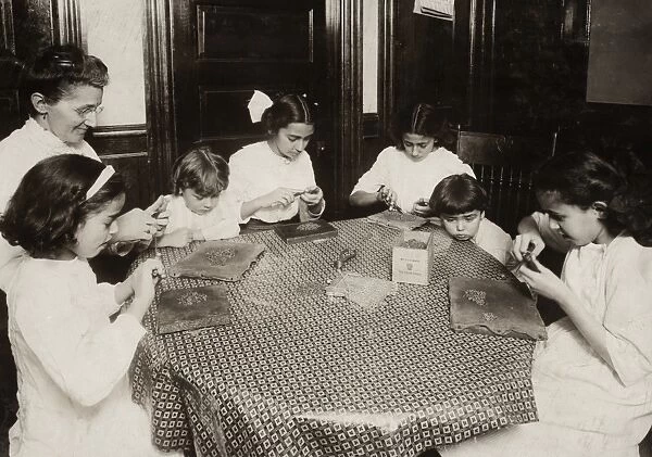HINE: HOME INDUSTRY, 1912. A woman and children sitting around a table making chains