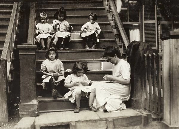 HINE: HOME INDUSTRY, 1912. A woman with a group of young girls working on garment