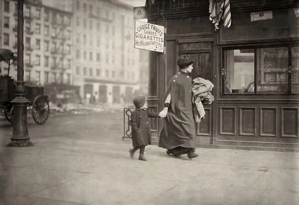 HINE: HOME INDUSTRY, 1912. A woman and son carrying clothing for home-work near