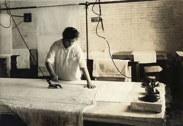 HINE: IRONING, 1917. A fifteen-year-old girl pressing curtains at Boutwell, Fairclough