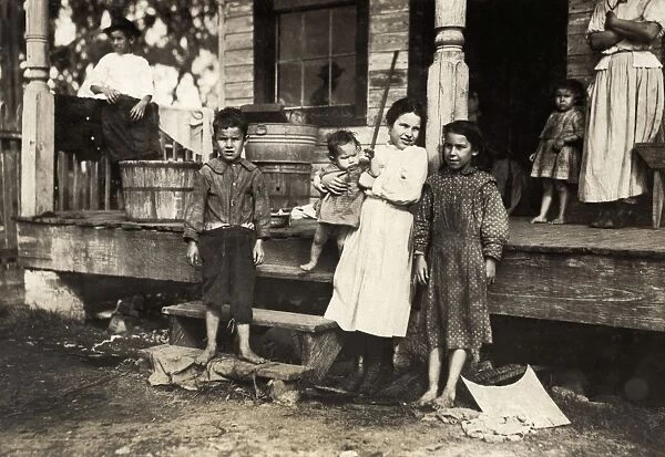 HINE: POVERTY, 1911. An impoverished family, all except the smallest baby work