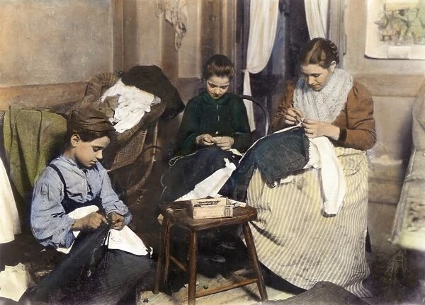 HOME INDUSTRY, c1910. An immigrant family making mens trousers in their New York