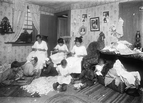 HOME INDUSTRY, c1910. Italian immigrant family doing garment piecework in their home
